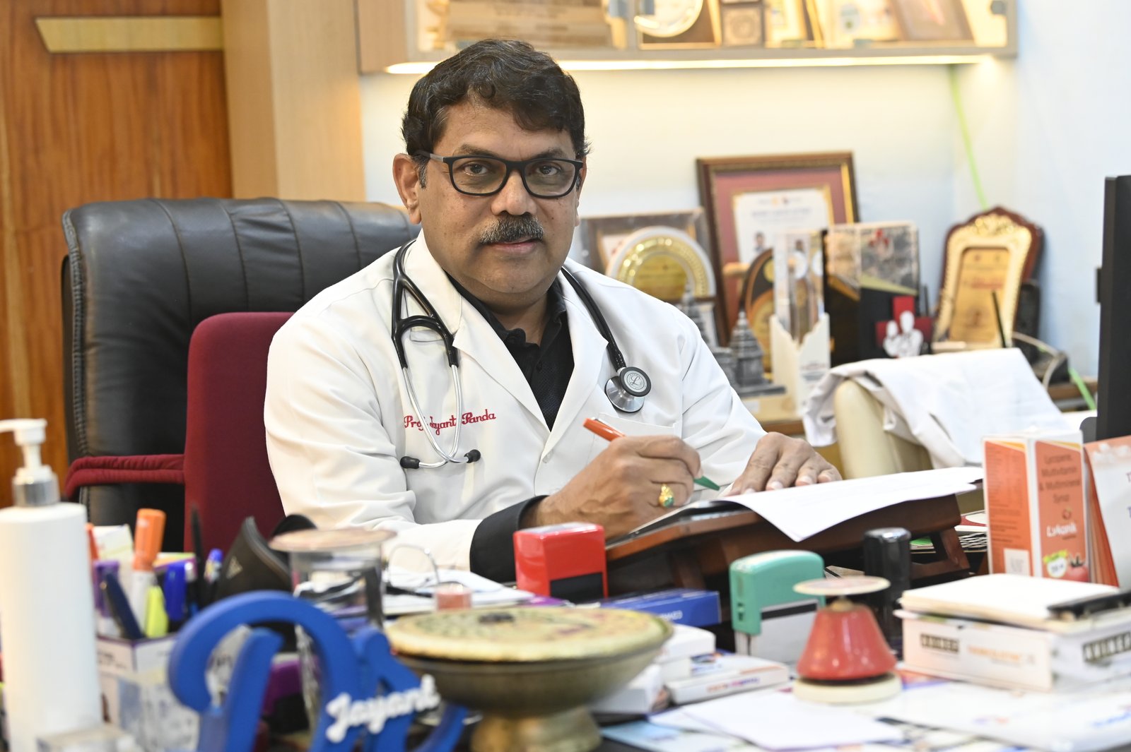 Dr Jayanta K. Panda in his clinic with awards displayed behind him